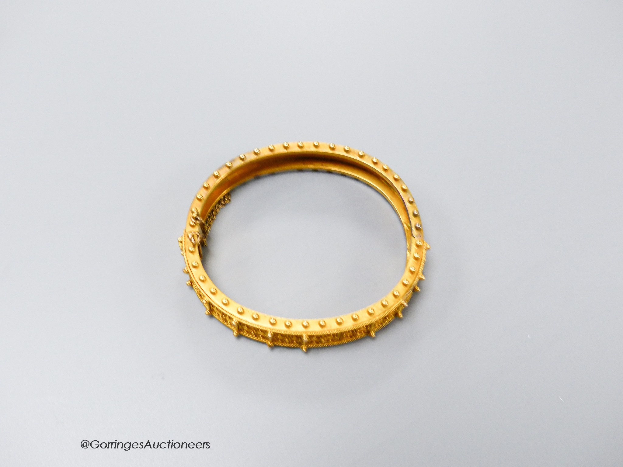 A cased Victorian yellow metal cannetile work hinged bracelet, inner diameter 55mm, 19.1 grams(a.f.).